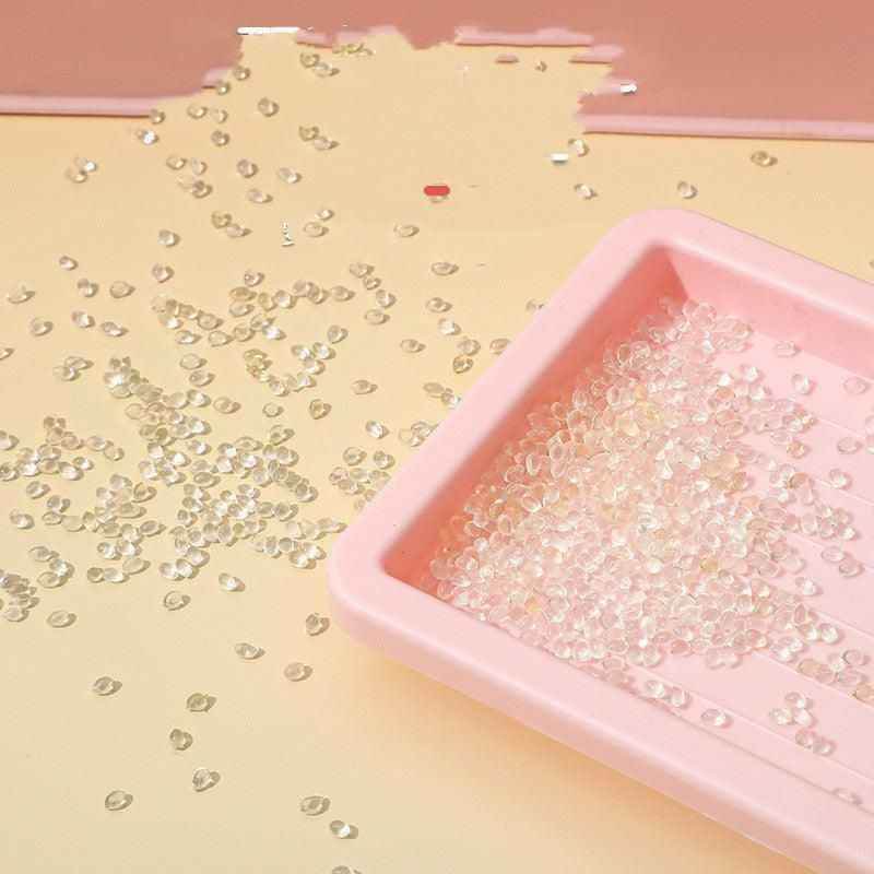 Clear plastic pellets in a pink tray used for manufacturing an Automatic Pet Feeder by Purrfect Pet Kingdom