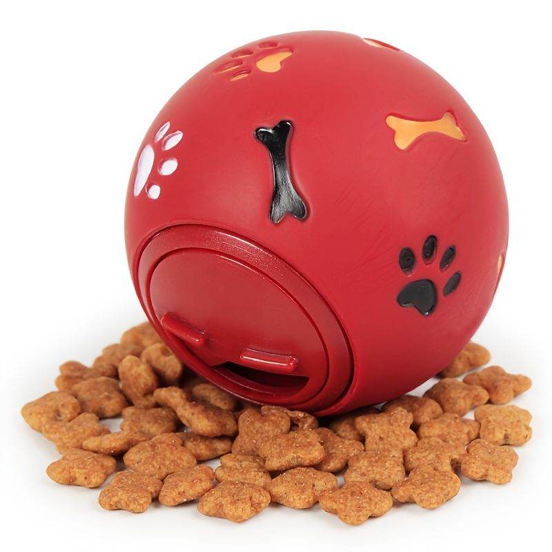 Purrfect Pet Kingdom red dog enrichment puzzle feeder ball with paw and bone cutouts surrounded by dog treats