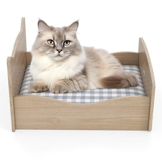 Elevated cat bed with frame in natural wood finish, featuring a cushioned plaid mattress for comfort