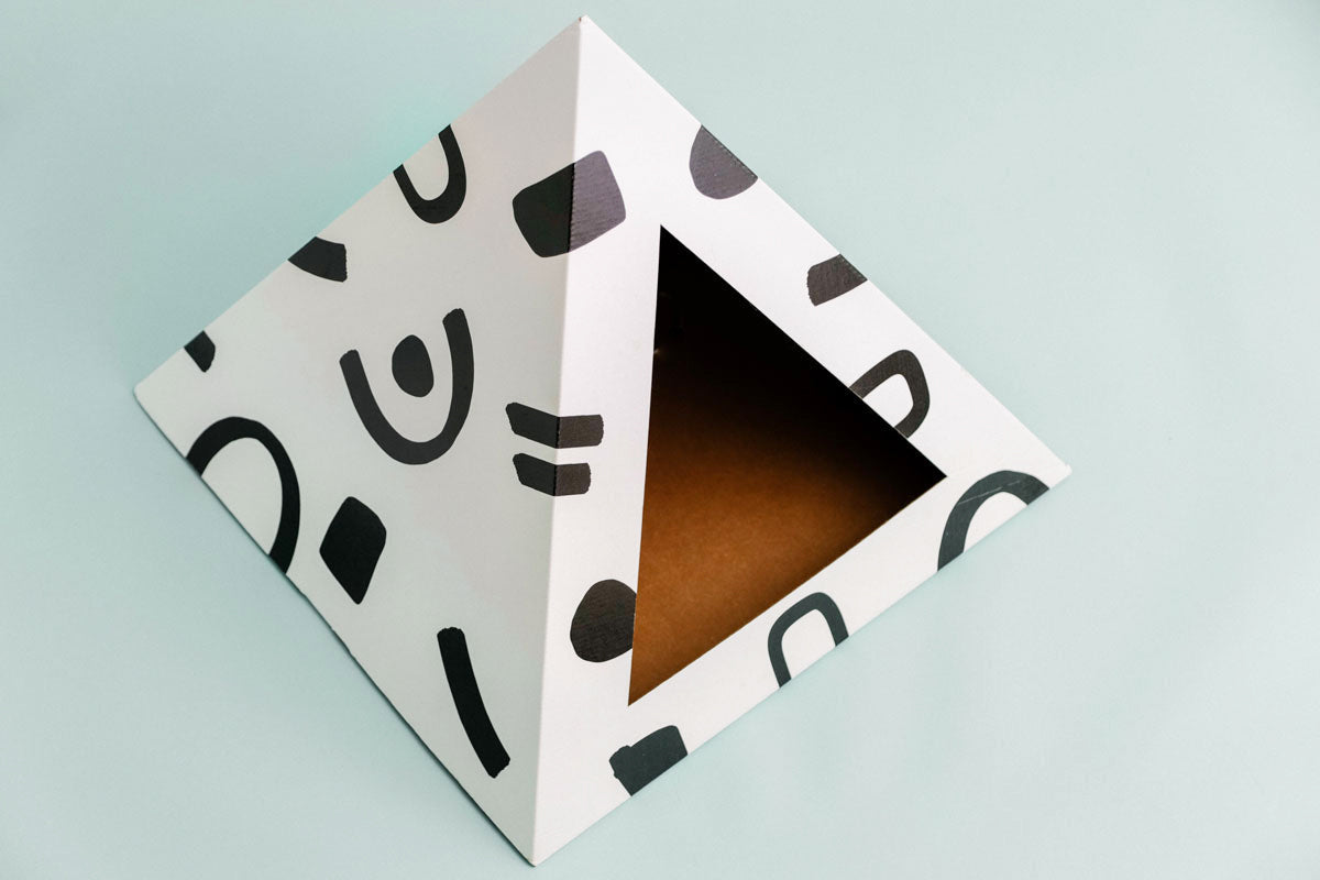 Stylish modern cardboard cat furniture in a pyramid shape featuring abstract black designs