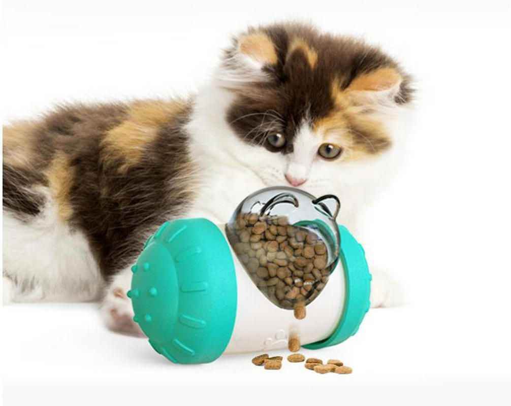 Calico kitten playing with Purrfect Pet Kingdom pet snack dispensing puzzle toy filled with dry treats