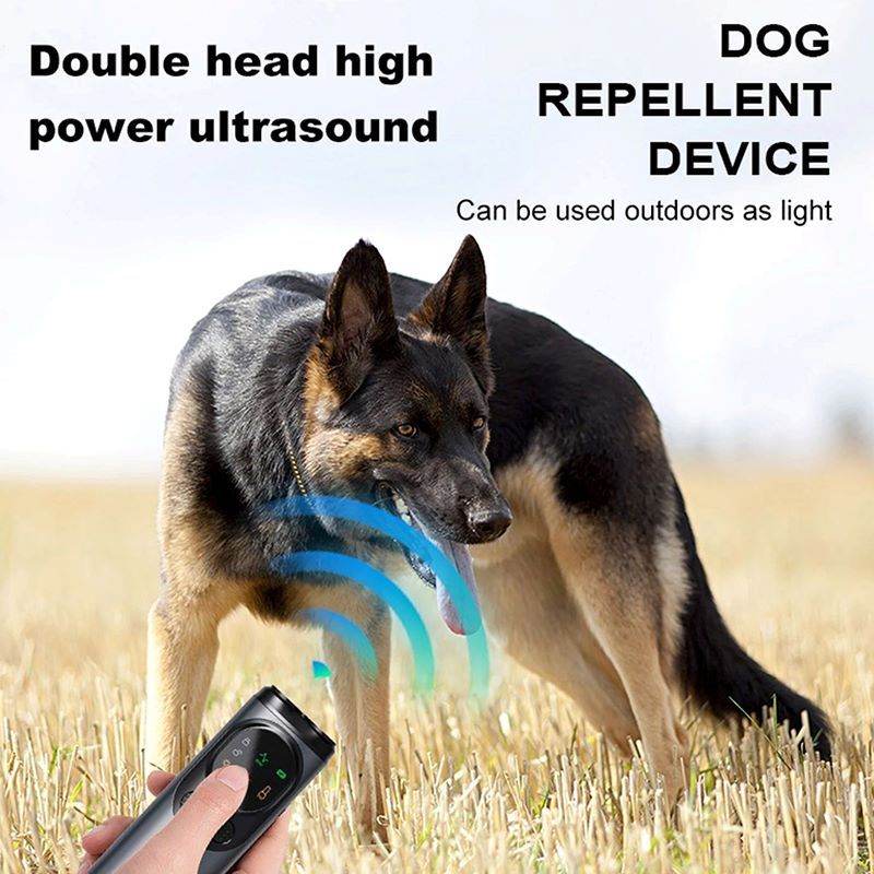 Stop dog barking tool ultrasonic dog repellent device held near German Shepherd in field