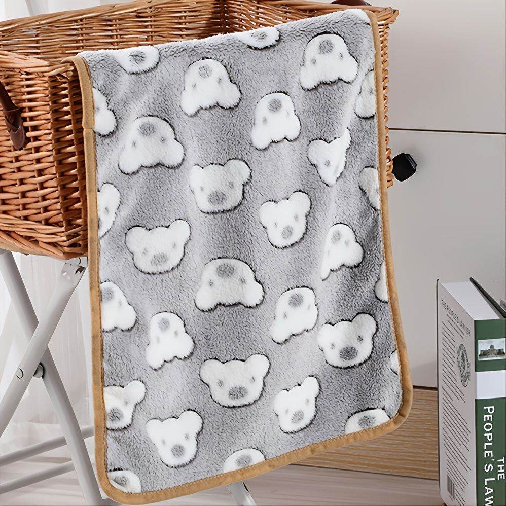 Cozy gray warming pet pad for cats and dogs with white bear faces pattern hanging over wicker basket