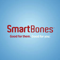 Happy dog chewing a wholesome, rawhide-free treat in a bright, cozy living room with warm, cheerful lighting.