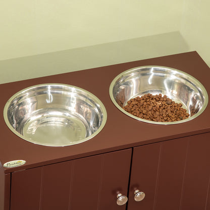 Elevated brown wood dog feeder cabinet with two stainless steel bowls and a storage compartment with silver knobs.