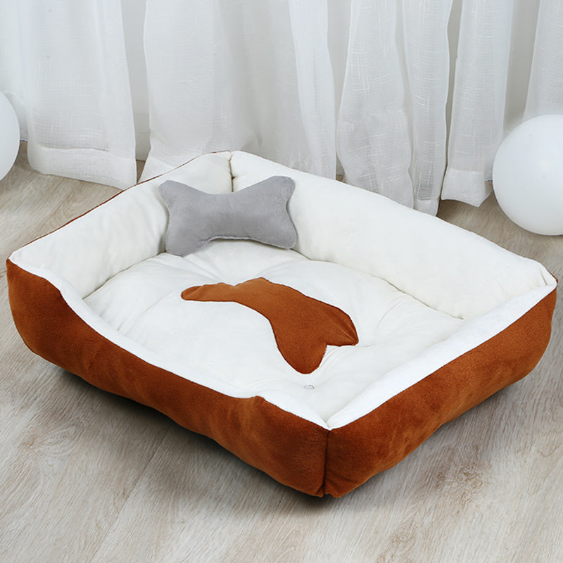 Estely brown and white plush bolster dog bed with a bone patch and a matching gray bone pillow.