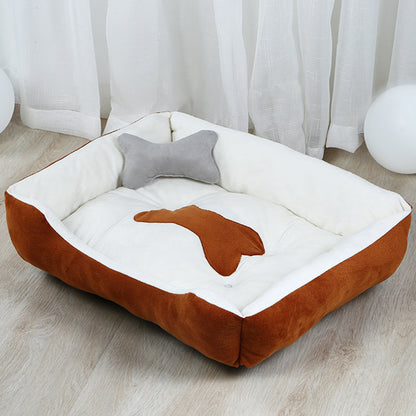 Estely brown and white plush bolster dog bed with a bone patch and a matching gray bone pillow.