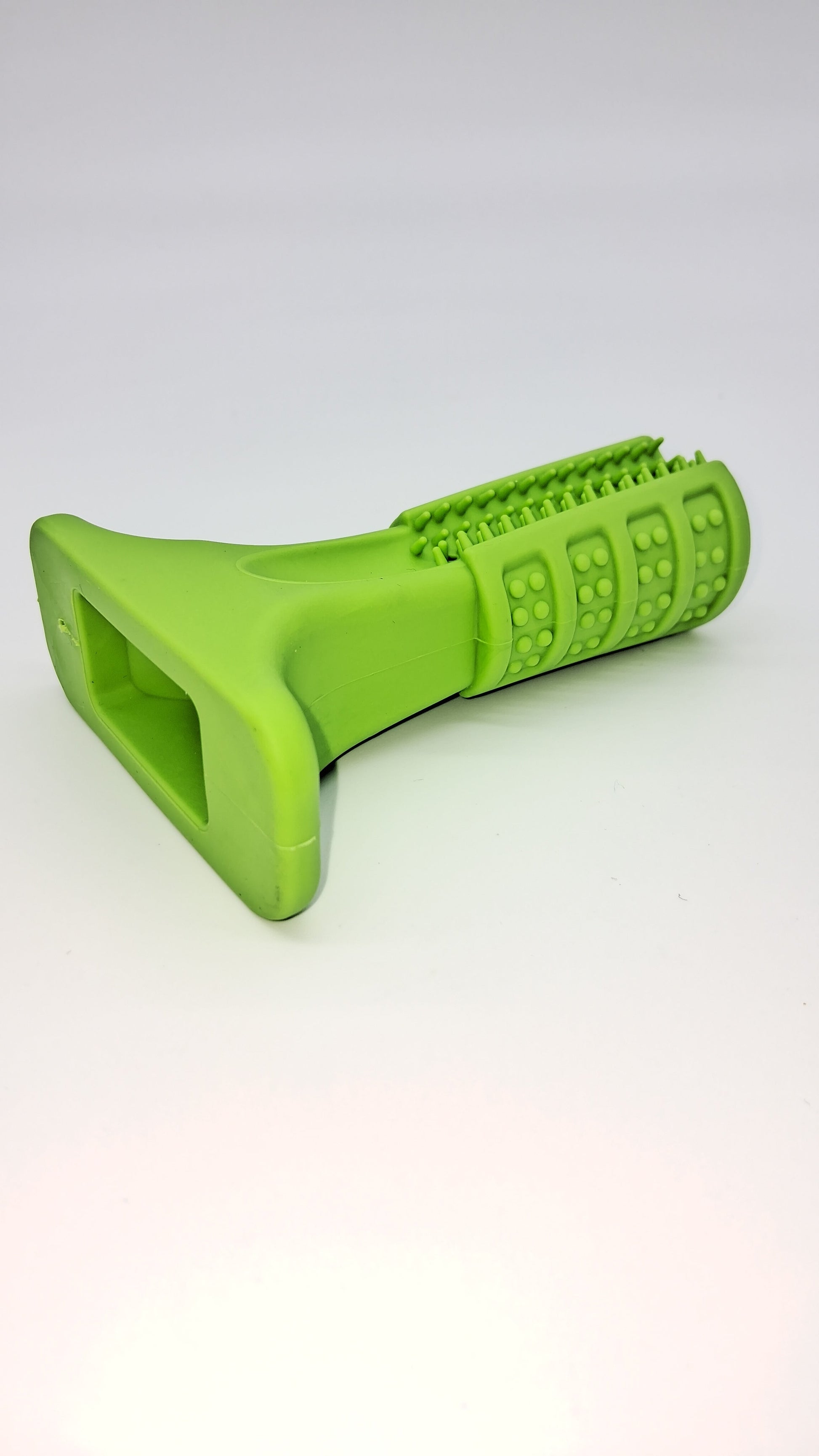 Lime green textured rubber dog chew toy 'The Grinder' with various dental nubs and a sturdy flat base.