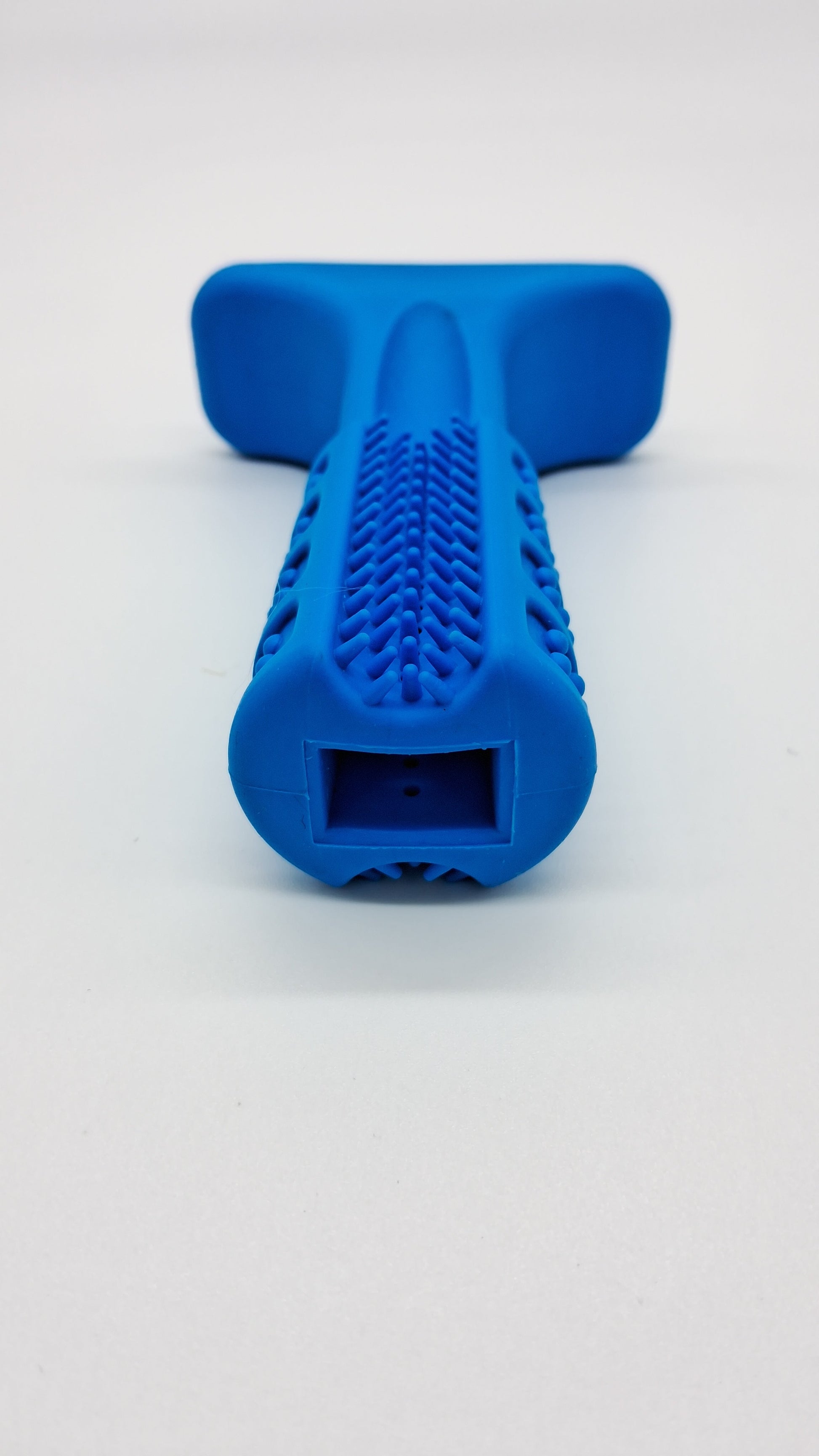 Blue rubber dental dog toy 'The Grinder' by Toys N Treats Box with cleaning bristles and treat opening.