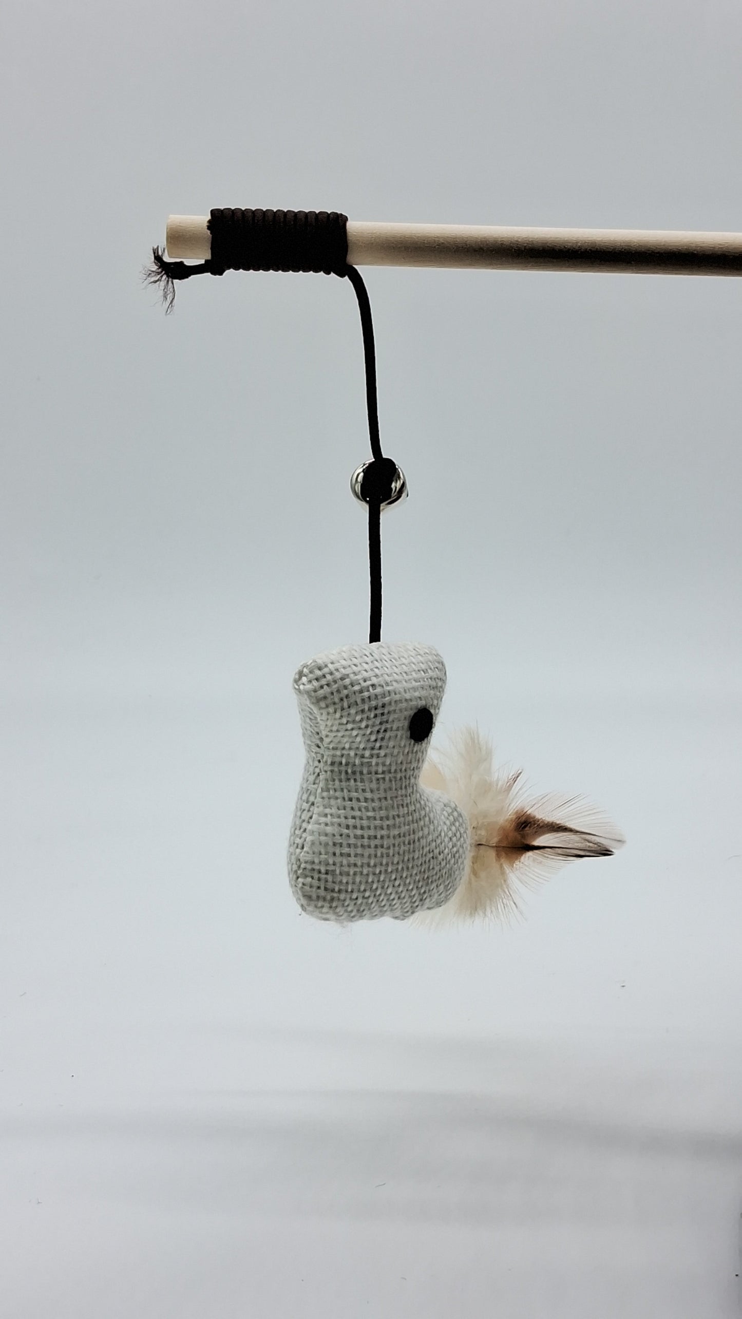 Toys N Treats Box wooden cat teaser wand featuring a grey burlap bird toy with brown feathers and a bell.