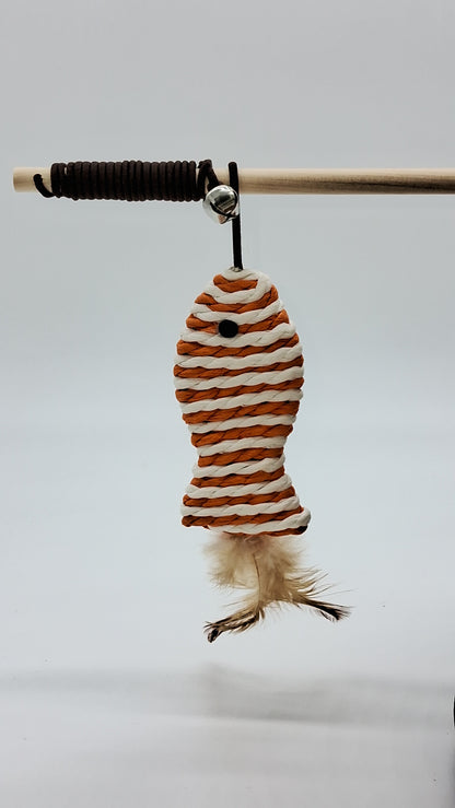 Toys N Treats Box cat teaser wand with wooden rod, bell, and orange and white woven rope fish with feather tail.