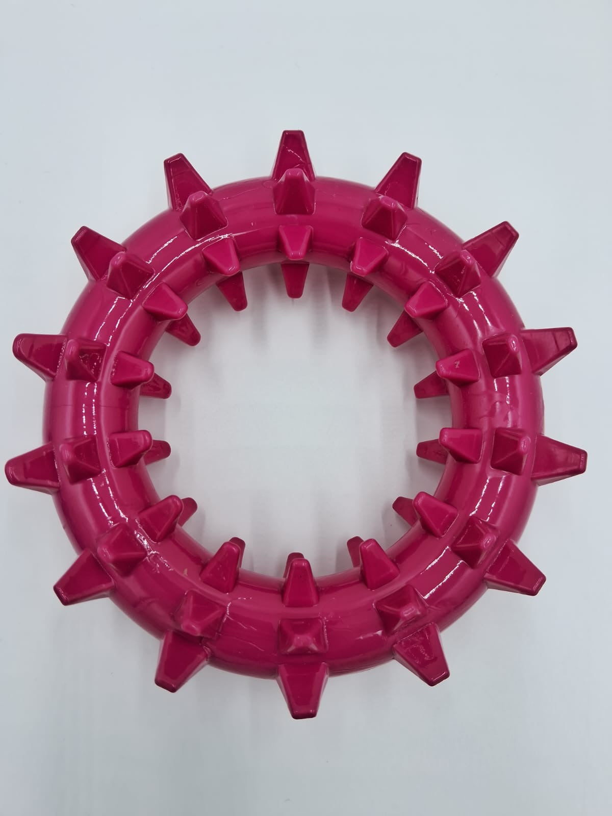 Bright pink spiked rubber ring dog chew toy for interactive enrichment by Toys N Treats Box.
