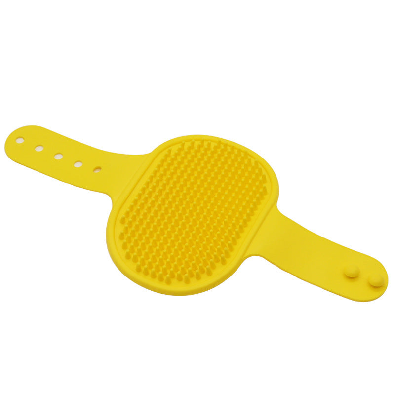 Yellow silicone pet bath brush with soft bristles and an adjustable strap for gentle grooming and deshedding.