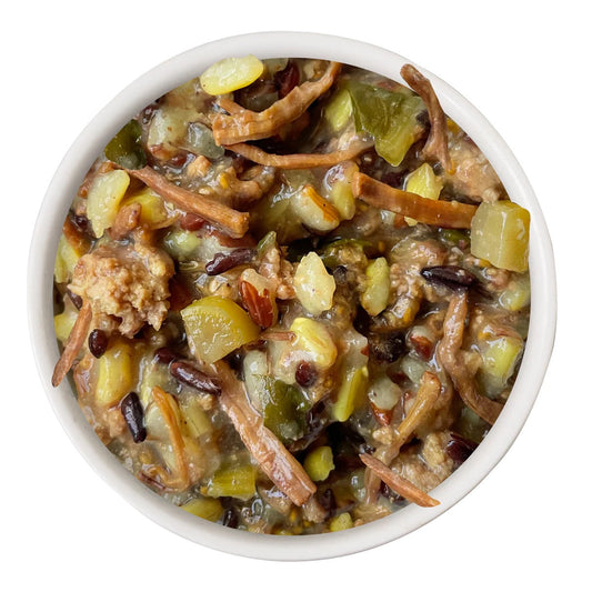 White bowl filled with a mix of dried fruits and nuts on a white background