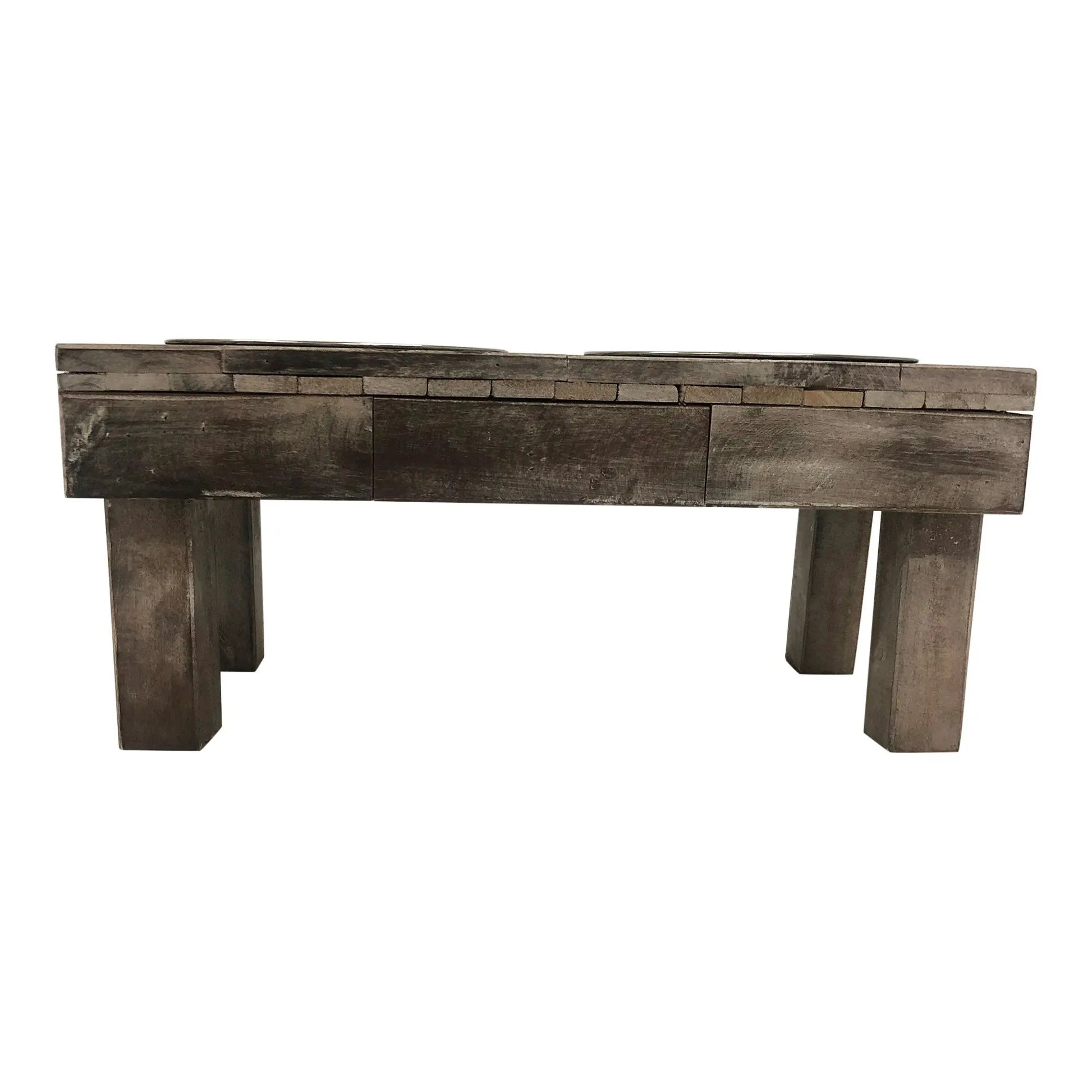 Rustic weathered grey wood elevated pet feeder table with two metal bowls and thick block legs.