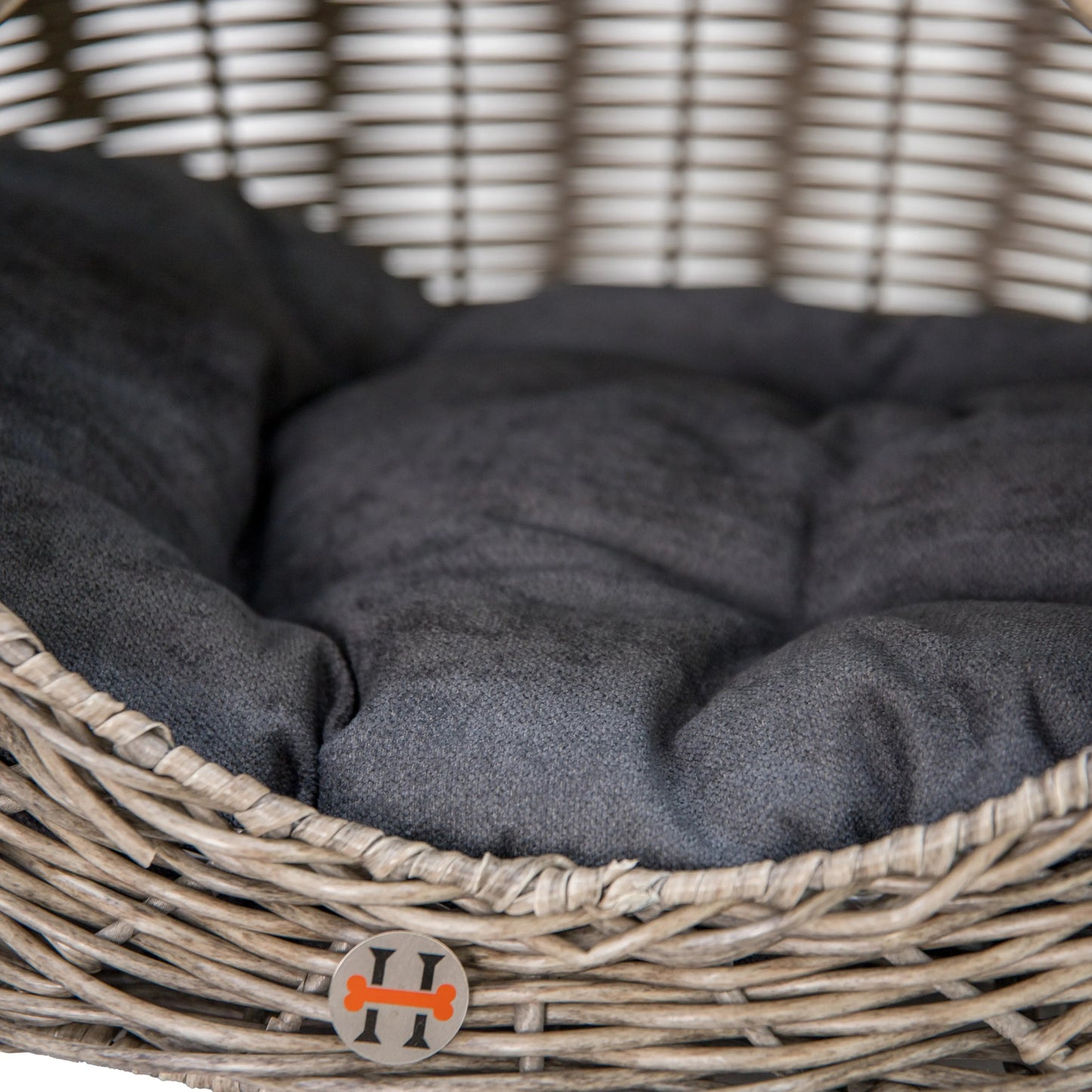 Huntley Equestrian grey woven wicker dog bed with a plush charcoal cushion and small logo tag.