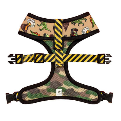 Jurassic Bark reversible harness: tan dinosaur print, camo mesh, yellow hazard-striped straps, buckles, and D-ring.