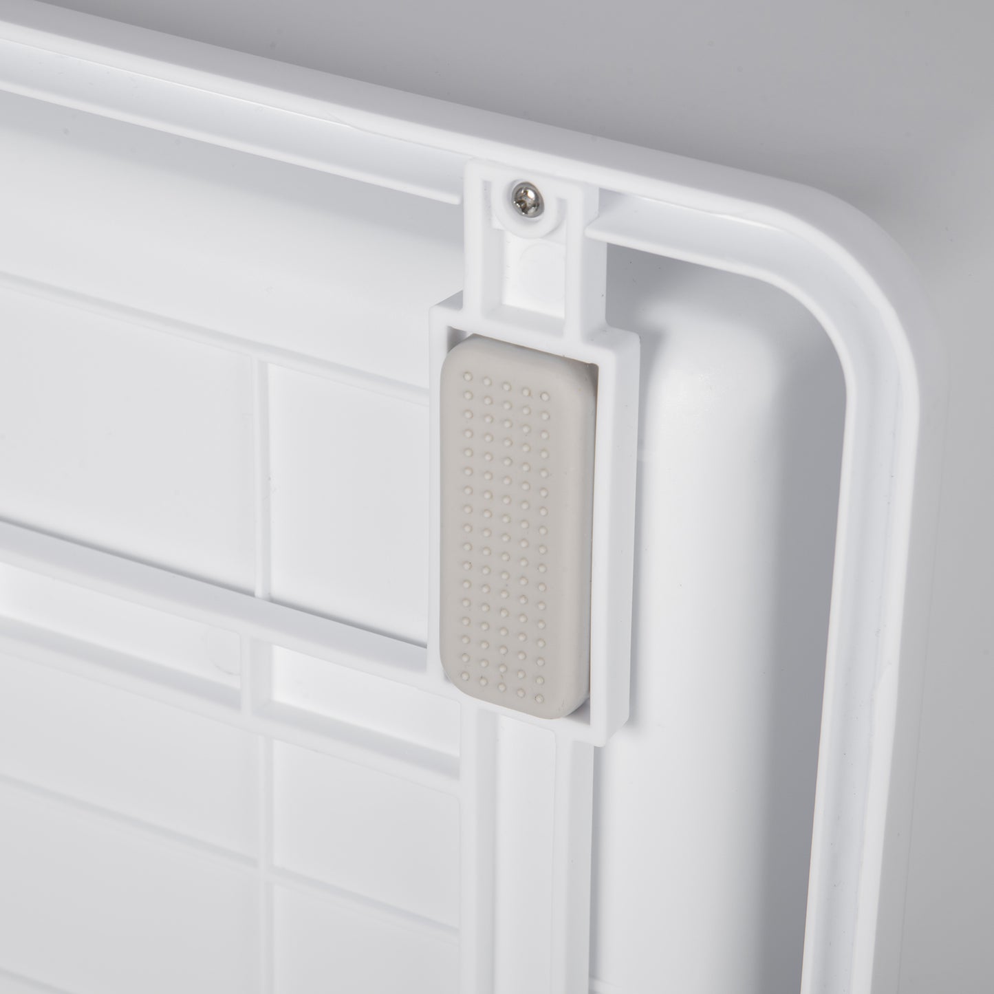 Close-up of a white plastic litter box base featuring a grey non-slip rubber foot for stability.