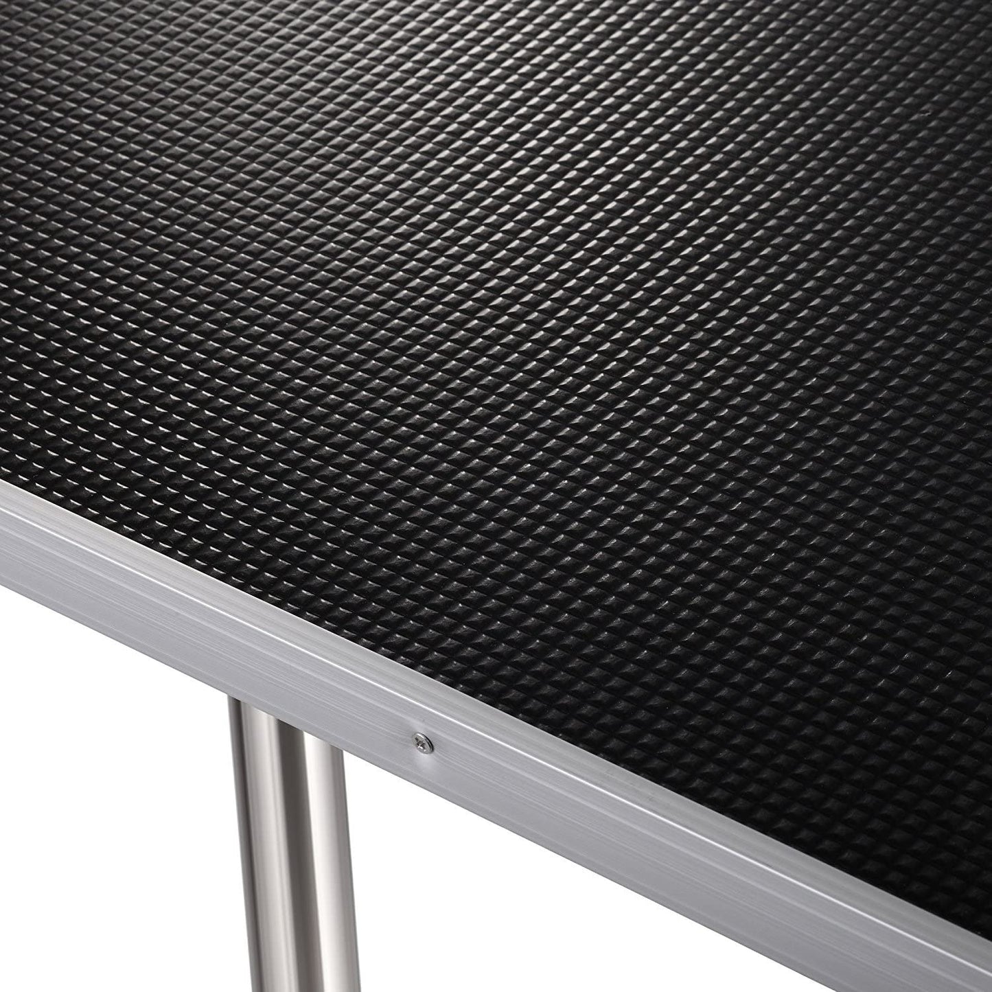 Close-up of an adjustable dog grooming table with a textured surface for stability during grooming