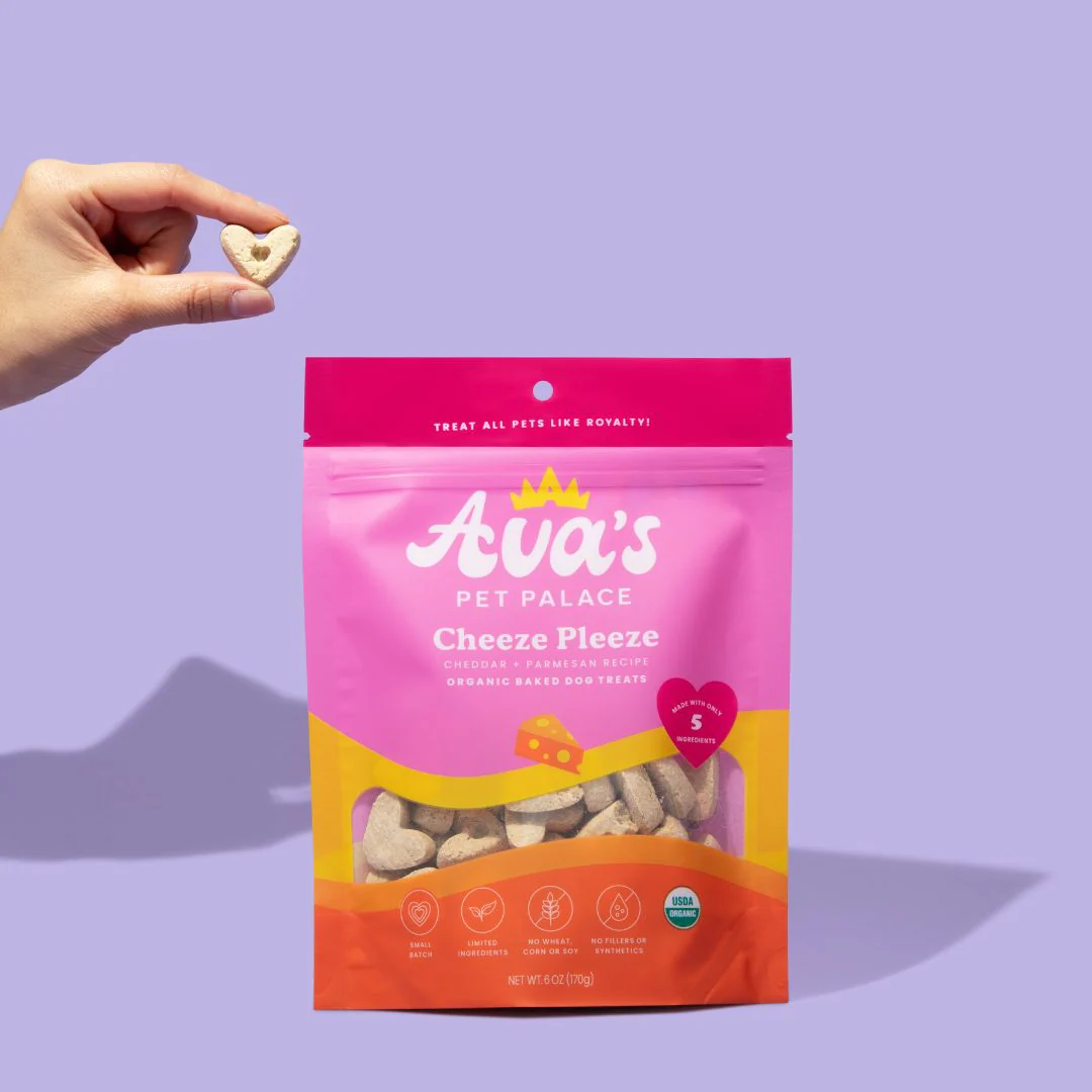Ava's Cheeze Pleeze gourmet dog treats in a colorful packaging held by a hand for pet owners