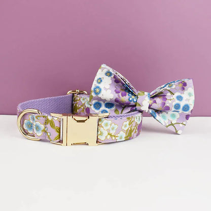 Lilac floral dog collar and bow tie with gold hardware, featuring white and blue blossom pattern on purple fabric.