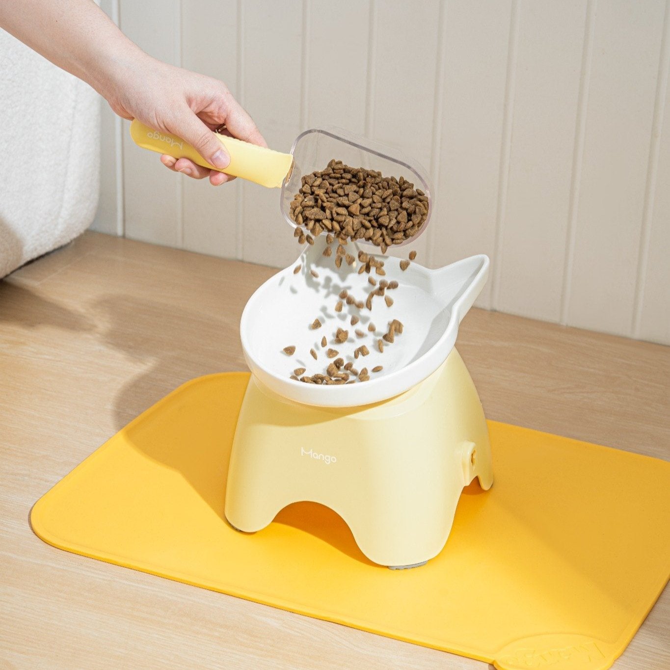 MangoPets dog and cat food serving spoon pouring kibble into a stylish food container