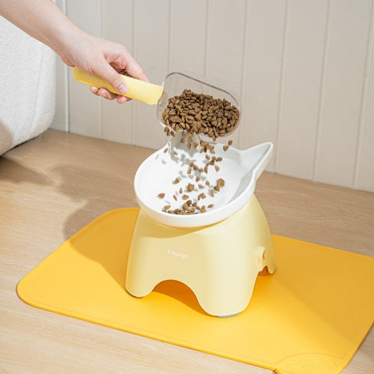 MangoPets dog and cat food serving spoon pouring kibble into a stylish food container