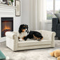 Noble Dog Bed by Purrfect Pet Kingdom with plush cream fabric and rolled arms featuring a black and white dog lying on it near a fireplace