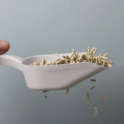 Durable cat litter cleaning tool gray scoop with wood pellet litter being scooped and shaken