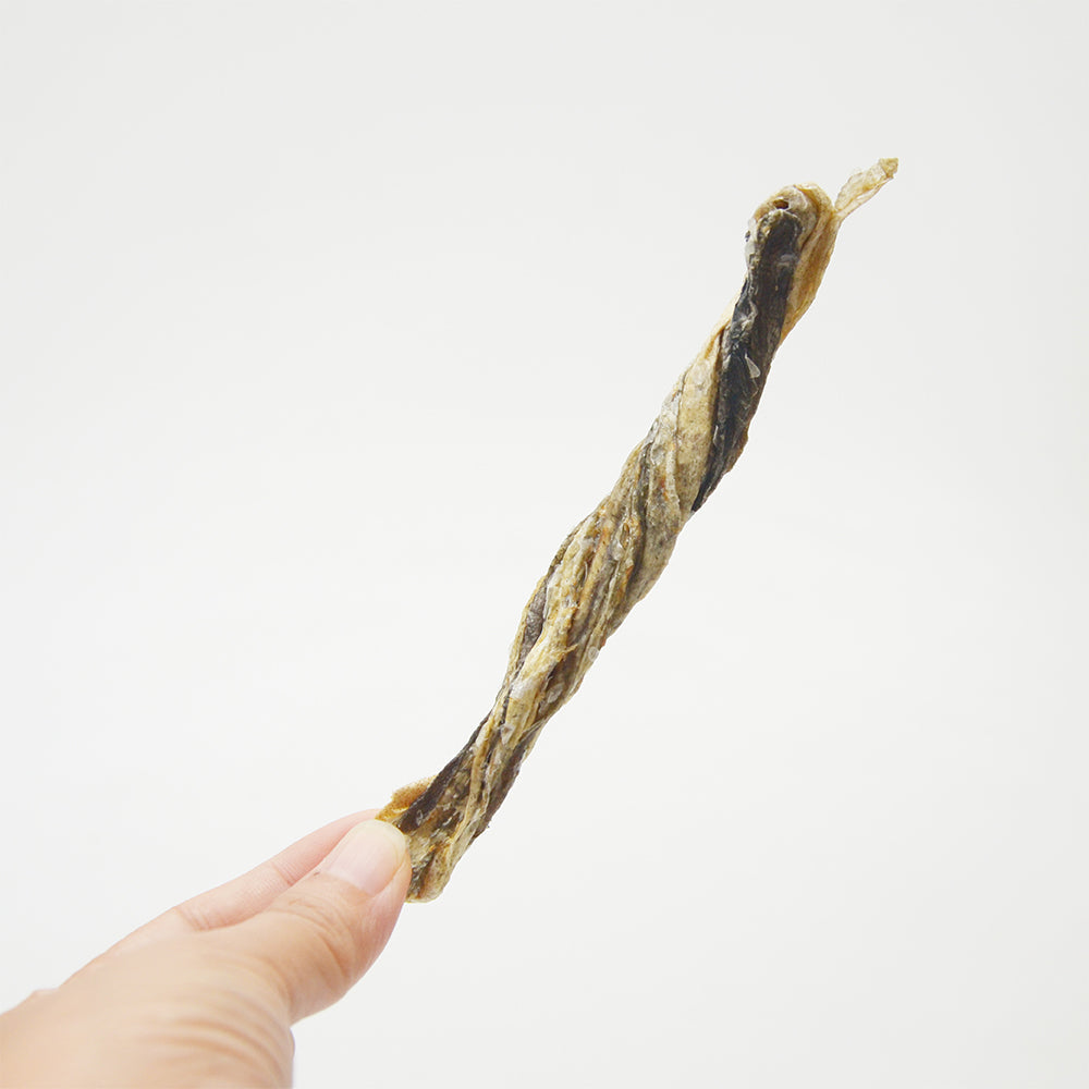 Hand holding Jack PetPals codfish treats 6oz, a healthy snack for dogs, showcasing its twisty shape