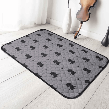 Gray washable pee pads for cats and dogs with black paw and pet patterns on hardwood floor