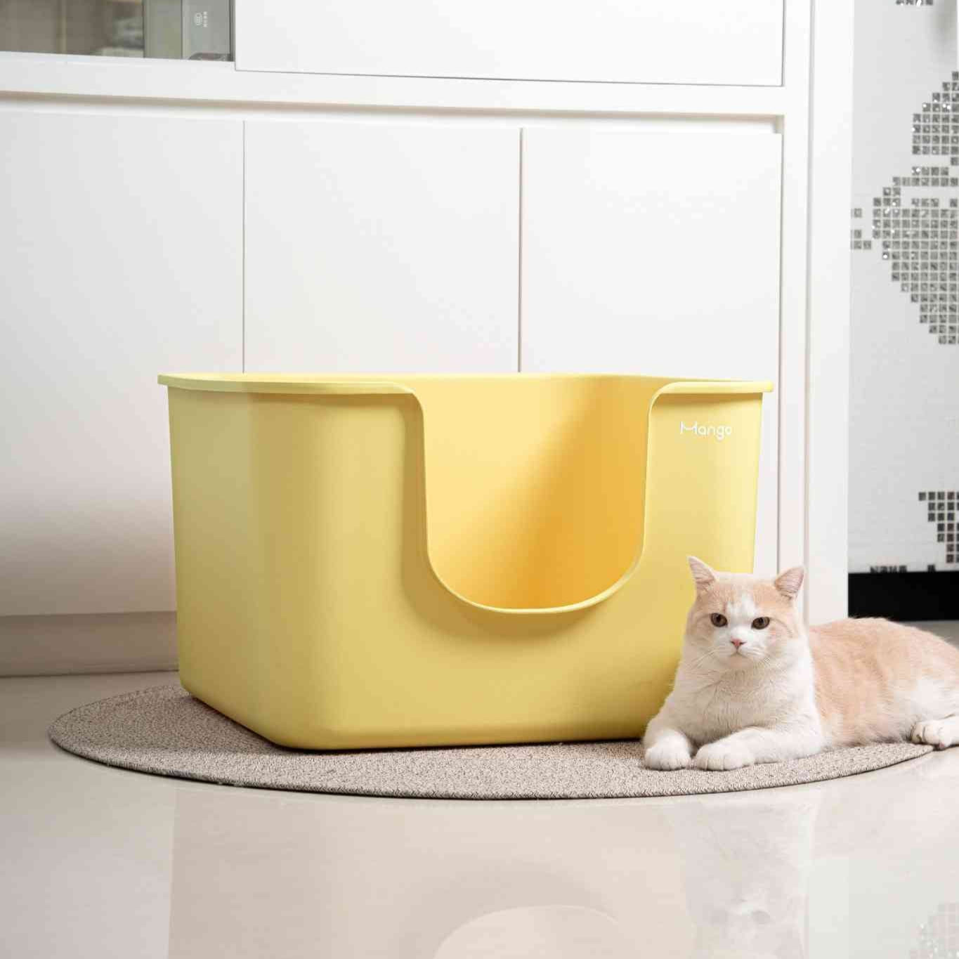 Mango color jumbo litter box by MangoPets with a sleek design and a cat resting beside it