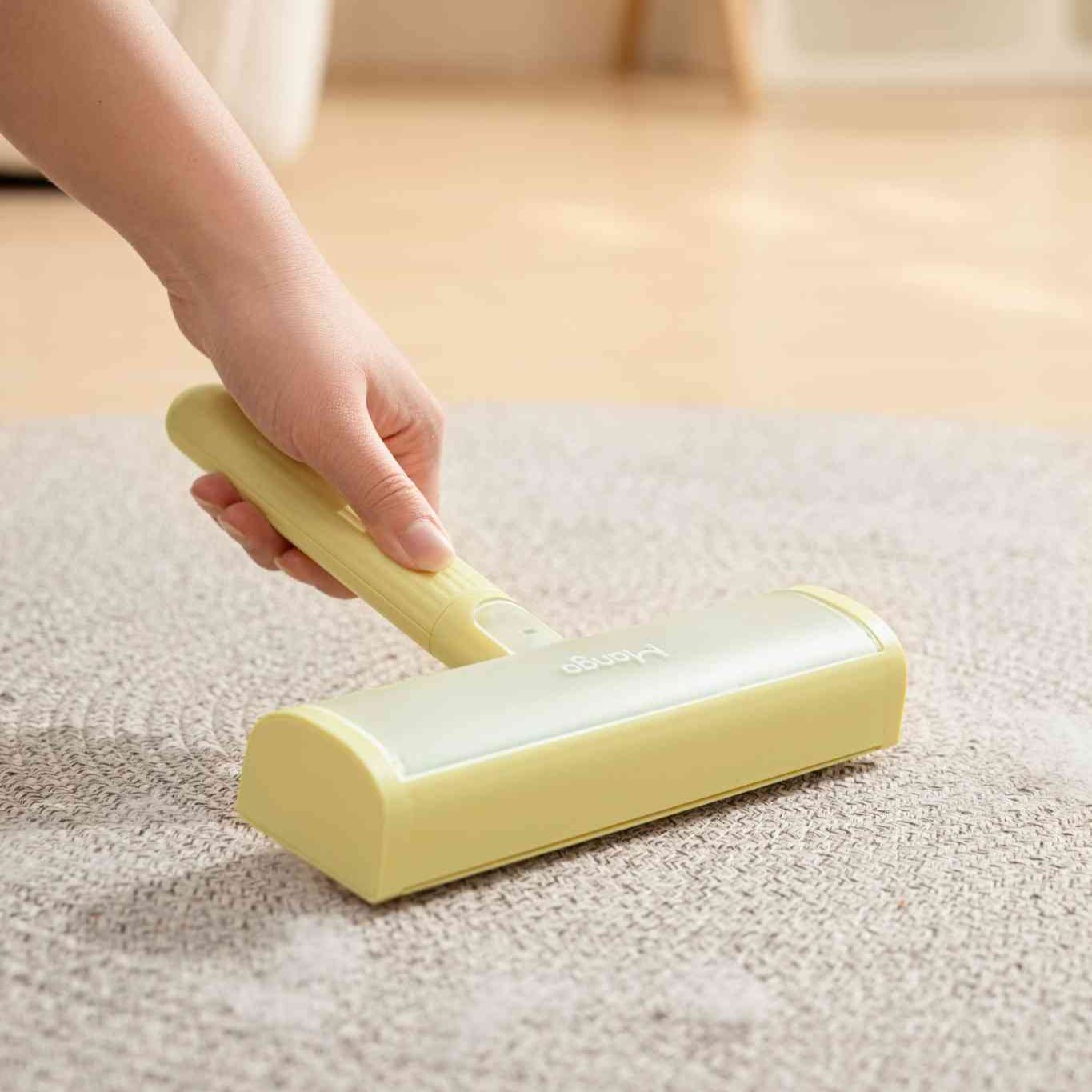 MangoPets reusable lint roller for pets being used on a carpet to remove lint and pet hair