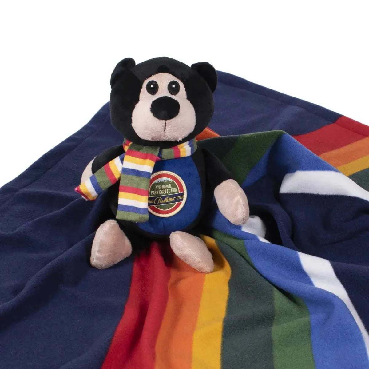 K9 Outdoors plush bear toy on a Pendleton National Park pet blanket with colorful stripes