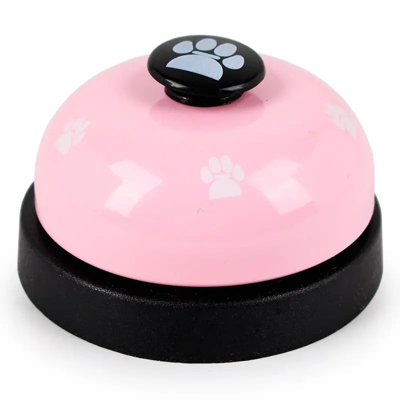 Pink pet behavior training bell from WTN Essentials with paw print design for pet communication