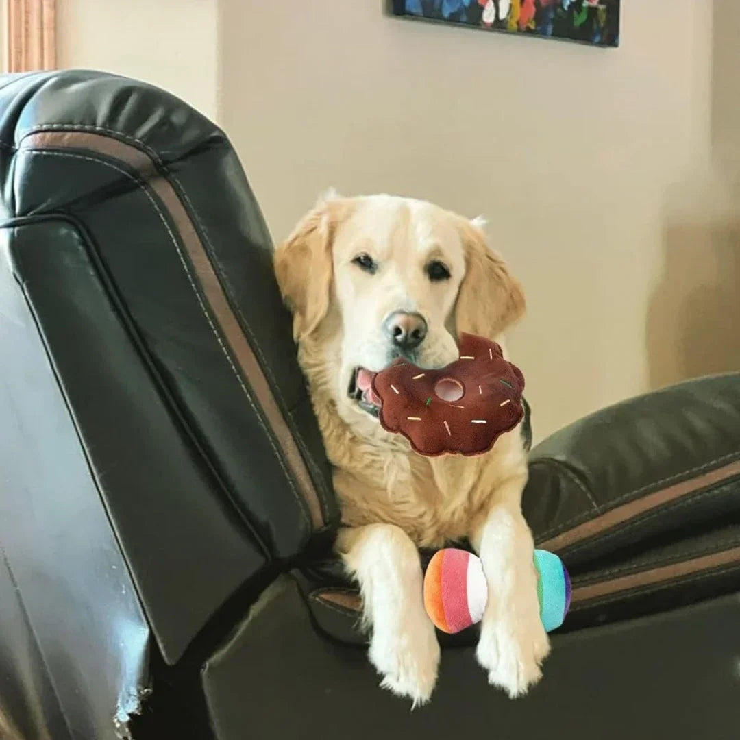 Golden retriever playing with plush puppy toy set on a recliner, featuring colorful toys for dogs