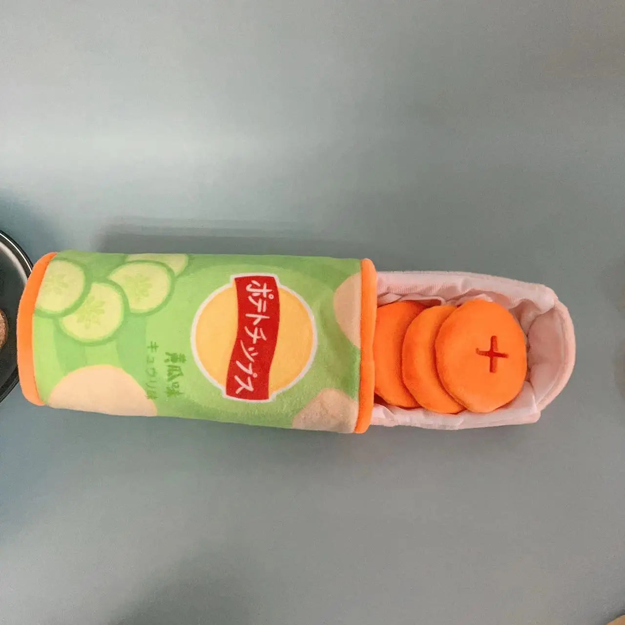 Soft food-themed dog toy for pets shaped like oranges in a colorful container