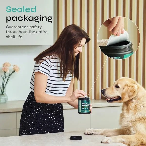 Woman opening sealed container of dog anxiety relief chews for travel with a golden retriever looking on