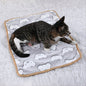 Cozy cat lying on a warming pet pad for cats and dogs with paw and bone patterns