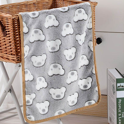 Gray warming pet pad for cats and dogs with cute white bear faces and brown trim draped over wicker basket